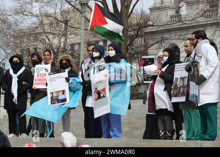 Harrisburg, Stati Uniti. 24 febbraio 2024. Gli operatori sanitari tengono dei cartelli durante l'Healthcare Workers for Palestine Rally sui gradini del Campidoglio della Pennsylvania. La Coalizione palestinese di Harrisburg insieme ad altre organizzazioni tra cui la Coalizione palestinese di Pittsburgh, la Penn State Students for Justice in Palestine e la Jewish Voice for Peace Philadelphia organizzarono la manifestazione per mostrare solidarietà agli operatori sanitari di Gaza e per chiedere un cessate il fuoco immediato. Credito: SOPA Images Limited/Alamy Live News Foto Stock