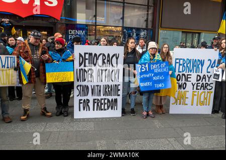 NEW YORK, NEW YORK - 24 FEBBRAIO: Le persone tengono i cartelli e le bandiere in un raduno per l'Ucraina in occasione del secondo anniversario dell'invasione russa dell'Ucraina a Times Square il 24 febbraio 2024 a New York. Entrando nel suo terzo anno, l'inflessibile guerra della Russia all'Ucraina ha sollevato preoccupazioni per quanto tempo i paesi occidentali continueranno a fornire armi e altro sostegno a Kiev. La fornitura di munizioni, armi e manodopera è ora un fattore critico in un conflitto che ha causato oltre mezzo milione di vittime e ha causato il diffuso trasferimento di civili. Foto Stock