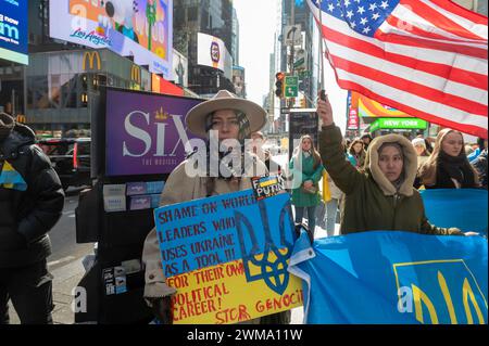 NEW YORK, NEW YORK - 24 FEBBRAIO: Le persone tengono i cartelli e le bandiere in un raduno per l'Ucraina in occasione del secondo anniversario dell'invasione russa dell'Ucraina a Times Square il 24 febbraio 2024 a New York. Entrando nel suo terzo anno, l'inflessibile guerra della Russia all'Ucraina ha sollevato preoccupazioni per quanto tempo i paesi occidentali continueranno a fornire armi e altro sostegno a Kiev. La fornitura di munizioni, armi e manodopera è ora un fattore critico in un conflitto che ha causato oltre mezzo milione di vittime e ha causato il diffuso trasferimento di civili. Foto Stock