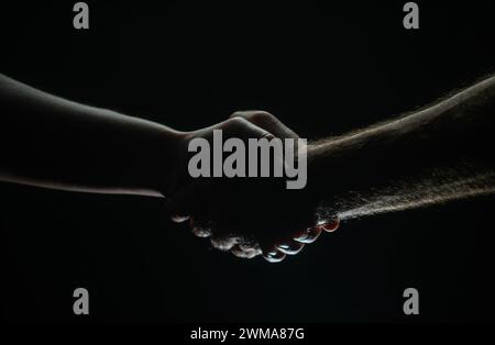 Stretta di mano tra i due partner, accordo. Salvataggio mani maschili. Stretta di mano amichevole, saluto degli amici, amicizia. Salvataggio, aiuto gestuale o mani Foto Stock