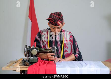 Il sarto fa la bandiera nazionale indonesiana prima del giorno dell'indipendenza Foto Stock