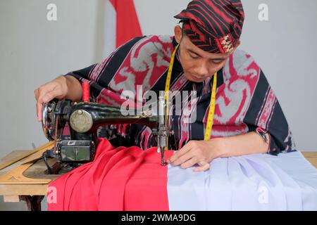 Il sarto fa la bandiera nazionale indonesiana prima del giorno dell'indipendenza Foto Stock