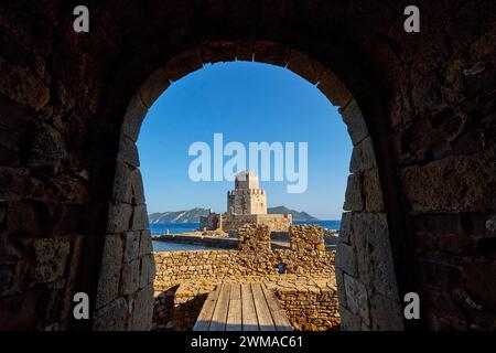 Vista attraverso un ingresso ad arco a un castello sul mare, torre medievale ottagonale. Isolotto di Bourtzi, fortezza marina di Methoni, Peloponneso, Grecia Foto Stock