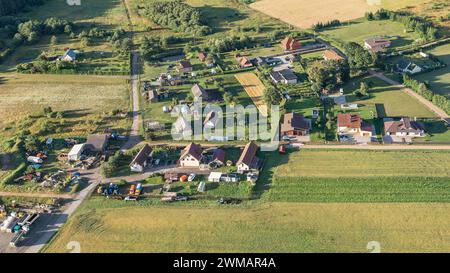 Paesaggio del villaggio dall'alto, vista aerea di case rurali private tra campi verdi della pianura. Foto Stock