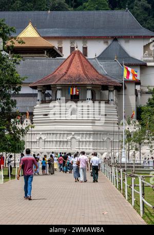 I visitatori camminano verso la Torre ottagonale del Tempio della reliquia del Sacro dente a Kandy nello Sri Lanka. Foto Stock