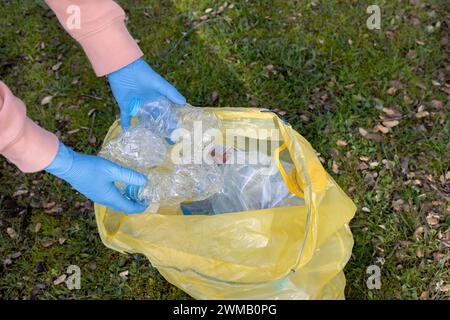 Persona che effettua un giorno di raccolta dei rifiuti di plastica sul campo. Concetto di riciclaggio, pulizia Foto Stock