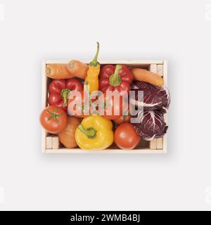 Verdure fresche e gustose rosse e gialle in casse di legno concetto di mangiare sano e isolato Foto Stock