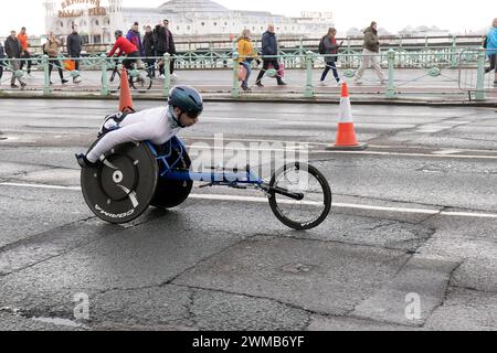 Kings Road, Brighton, City of Brighton & Hove, East Sussex, Regno Unito. Il primo corridore su sedia a rotelle di questa edizione della mezza maratona di Brighton sotto un cielo nuvoloso e basse temperature lungo il lungomare di Brighton & Hove. 25 febbraio 2024. David Smith/Alamy Live News Foto Stock