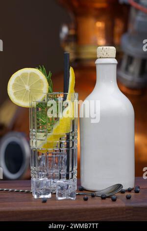 Gin cocktail con bottiglia di ceramica bianca davanti alla distilleria. Foto Stock