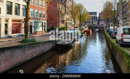 Amsterdam, Nedherlands - 5 novembre 2017: Skyline del centro città con case in mattoni e barche. Famoso punto di riferimento della vecchia città europea in autunno. Foto Stock