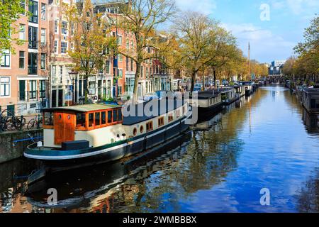 Amsterdam, Nedherlands - 5 novembre 2017: Skyline del centro città con case in mattoni e barche. Famoso punto di riferimento della vecchia città europea in autunno. Foto Stock