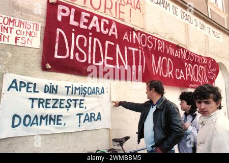 Brasov, Romania, aprile 1990. A seguito della rivoluzione anti-comunista del 1989, sono scoppiate proteste in tutto il paese contro gli ex funzionari comunisti che hanno immediatamente afferrato il potere. Nella piazza centrale di Brasov, la gente legge manifesti e striscioni che hanno condannato il nuovo partito al potere, F.S.N. Foto Stock