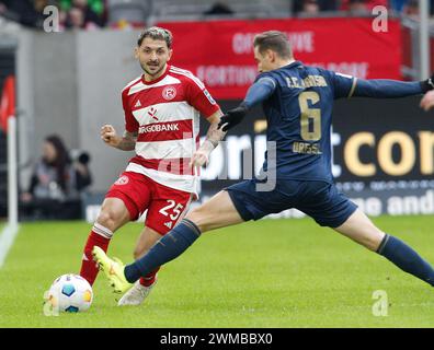 Duesseldorf, Germania. 25 febbraio 2024. Calcio: Bundesliga 2, fortuna Düsseldorf - Hansa Rostock, giorno 23, alla Merkur Spiel-Arena. Matthias Zimmermann (l) di Düsseldorf e Dennis Dressel di Rostock lottano per il ballo. Credito: Roland Weihrauch/dpa - NOTA IMPORTANTE: in conformità con i regolamenti della DFL German Football League e della DFB German Football Association, è vietato utilizzare o far utilizzare fotografie scattate nello stadio e/o della partita sotto forma di immagini sequenziali e/o serie di foto video./dpa/Alamy Live News Foto Stock