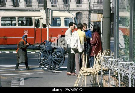 Repubblica Socialista di Romania, circa 1976. Scena nel centro di Bucarest, con un inserviente che passa accanto a un gruppo di giovani sul marciapiede. Foto Stock