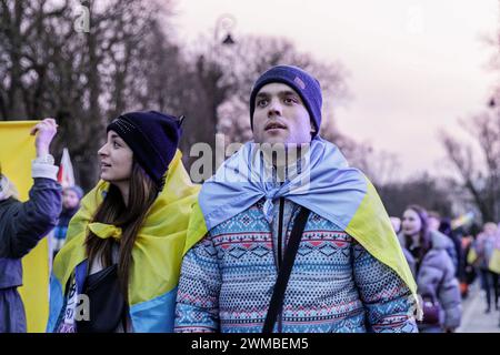 Varsavia, Polonia. 24 febbraio 2024. Una donna e un uomo avvolti da bandiere ucraine partecipano alla marcia per le strade di Varsavia, dedicata al secondo anniversario dell'invasione su vasta scala della Russia in Ucraina. La Polonia è un paese che, nei primi giorni dell'invasione su vasta scala della Russia in Ucraina il 24 febbraio 2022, ha accettato il maggior numero di rifugiati dall'Ucraina. Nel secondo anniversario dell'invasione su vasta scala, diverse migliaia di persone hanno partecipato alla manifestazione vicino all'Ambasciata della Federazione Russa a Varsavia. Credito: SOPA Images Limited/Alamy Live News Foto Stock