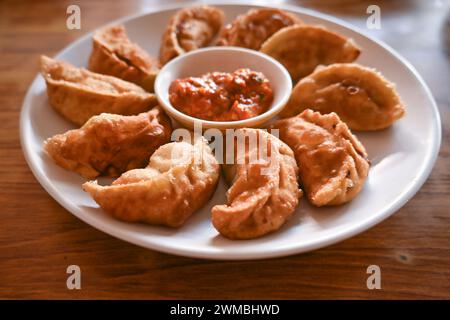 Primo piano di dieci momos di pollo fritti, tipici gnocchi ripieni Foto Stock