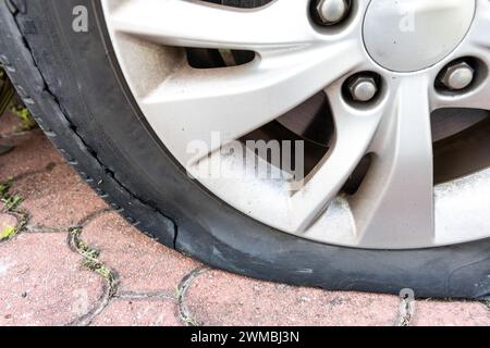 Primo piano dello pneumatico sgonfio per auto a causa della rottura sul lato della ruota Foto Stock