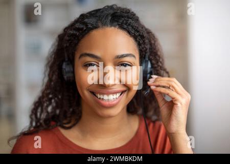 Operatore call center. Ritratto di una giovane donna nera in cuffia Foto Stock