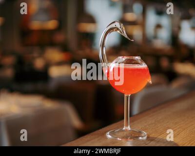 Cocktail cosmopolita in bicchierino di cigno sul bancone del bar. Popolare cocktail alcolico cosmopolita a base di vodka, triple sec, succo di mirtillo, succo di lime. Menu a barre con spazio di copia Foto Stock