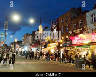 Vista di Camden High Street di notte, ancora affollata di acquirenti e turisti a Londra nel Regno Unito Foto Stock