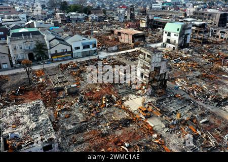 Ishikawa, Giappone. 25 febbraio 2024. (NOTA DELL'EDITORE: Immagine scattata con un drone) una vista aerea del mercato Wajima Asaichi di Wajima, che mostra cicatrici dell'incendio di Capodanno causato dal terremoto della penisola di noto. Un mese e mezzo dopo, molti detriti rimangono ancora intatti al mercato di Wajima Asaichi a Wajima, prefettura di Ishikawa, che è stato in gran parte distrutto da un incendio nel terremoto della penisola di noto. Le pareti danneggiate degli edifici e i telai in acciaio esposti mostrano la gravità dell'incendio. (Foto di James Matsumoto/SOPA Images/Sipa USA) credito: SIPA USA/Alamy Live News Foto Stock