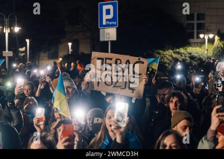 Un manifestante tiene un cartello durante il secondo anniversario dell'invasione russa. Migliaia di persone si sono radunate fuori dall'ambasciata della Federazione Russa a Varsavia e hanno marciato sul parlamento polacco mentre oggi segnano due anni di aggressione russa all'Ucraina. Foto Stock