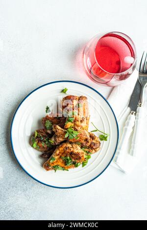 Vista dall'alto delle ali di pollo arrosto con coriandolo e una bevanda alla frutta Foto Stock