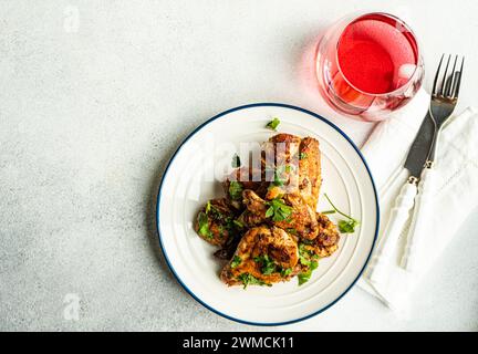 Vista dall'alto delle ali di pollo arrosto con coriandolo e una bevanda alla frutta Foto Stock
