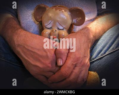 Primo piano di un uomo che coccola un orsacchiotto Foto Stock