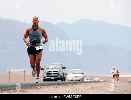 Death Valley, Stati Uniti d'America. 23 luglio 2007. David Goggins, operatore di guerra speciale della Marina degli Stati Uniti di prima classe, a sinistra, mantiene il ritmo mentre corre per 135 miglia attraverso il Scorching Death Valley National Park durante la Badwater Ultramarathon, 23 luglio 2007 a Death Valley, California. Goggins ha concluso la gara al terzo posto dopo 25 ore di corsa dal punto più basso negli Stati Uniti al punto più alto. Crediti: MCS Brandon Rogers/US Navy Photo/Alamy Live News Foto Stock