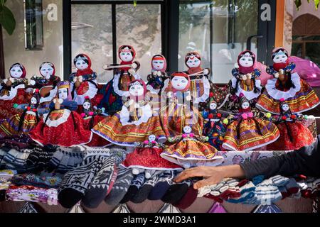 Stalla di bambole di stracci vestite con costumi tipici, la mano dell'artigiana appoggiata alla stalla, nel villaggio delle bambole di Soganli in Cappadocia Foto Stock