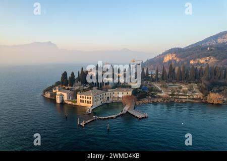 Punta San Vigilio - Vista aerea con droni in una giornata invernale di foschia al tramonto, luogo romantico del Lago di Garda chiamato Portofino del Lago di Garda. Northern Ital Foto Stock