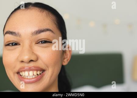 Una giovane donna birazziale sorride brillantemente, con spazio di copia Foto Stock