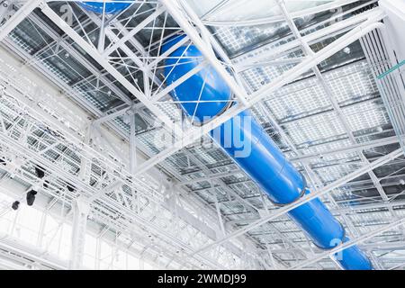 Interni industriali bianchi con struttura in acciaio per soffitti e rivestimento blu Foto Stock