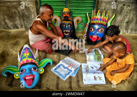 Il nonno insegna ai suoi nipoti usando un laptop nel villaggio vicino a Raignaj. Gomira è una forma di danza mascherata. La parola "Gomira" deriva dalla forma colloquiale della parola "Gram-Chandi" o la divinità femminile che è la forza protettiva del villaggio. L'origine esatta della forma di danza non è rintracciabile e la conoscenza è andata perduta nel tempo. La danza Gomira è una forma di danza rurale praticata principalmente nel distretto di Dinajpur nel Bengala Occidentale. Le danze di Gomira sono organizzate per placare la divinità per inaugurare le "forze buone" e cacciare le "forze malvagie". Di solito è organizzato durante la m. Foto Stock