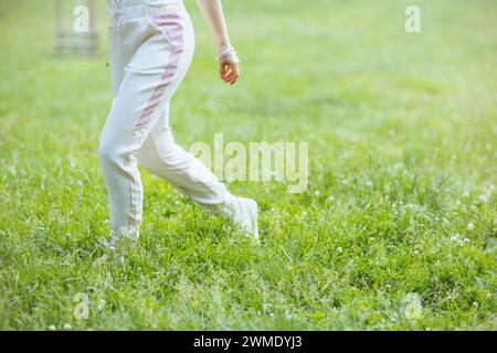 Ora legale. Primo piano su una donna che cammina nel prato del parco cittadino. Foto Stock