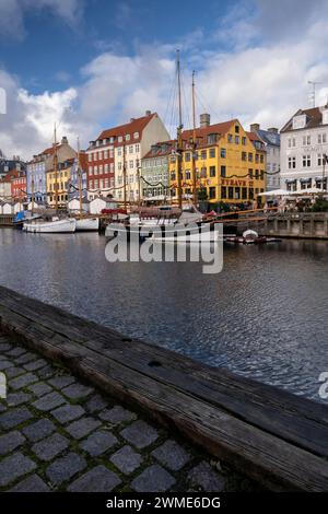 Edifici colorati e barche a alberi alti sul lungomare di Nyhavn, Copenhagen, Danimarca, Europa Foto Stock