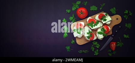 Panini freschi con formaggio, lattuga, pomodori, primo piano, vista dall'alto con spazio per il testo. Modello di cibo con preparazione di panini sani per snack o lu Foto Stock
