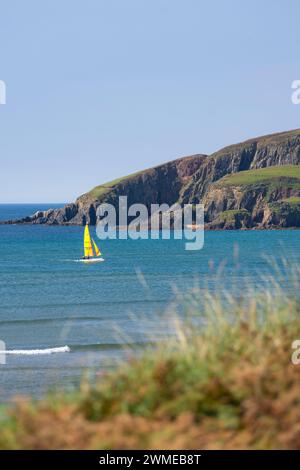 Barca a vela tra Bantham Beach e Burgh Island in una giornata estiva - Bantham, Devon, Regno Unito Foto Stock