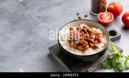 Curry di fagioli vegani con riso e pomodori. Cucina indiana. Piatto vegetariano. Foto Stock