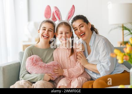 Buone vacanze. Madre e le sue figlie. La famiglia festeggia la Pasqua. Le bambine adorabili indossano orecchie da coniglio. Foto Stock