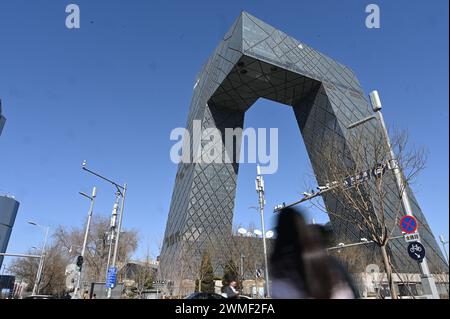 Pechino, Cina. 25 febbraio 2024. I passanti attraversano la strada di fronte al quartier generale della televisione di stato cinese CCTV. Credito: Johannes Neudecker/dpa/Alamy Live News Foto Stock