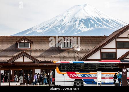 Stazione di Kawaguchiko in Giappone con il picco di neve del Monte Fuji visibile dietro, autobus autostradale di Tokyo con imbarco dei turisti, Giappone, Asia, 2023 Foto Stock