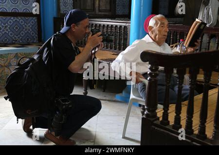 © Manoel Penicaud/le Pictorium/MAXPPP - Djerba 16/05/2014 Manoel Penicaud/le Pictorium - 16/05/2014 - Tunisie/Djerba/Djerba - Reporter Photographiant un vieux Rabbin Lisant la Torah. Chaque annee, pour la fete du Lag Ba'Omer, des juifs Tunisiens ayant emigre au XXe siecle en Europe, en Amerique du Nord et en Israel, reviennent en pelerinage a la sinagoga de la Ghriba a Djerba. Outre la dimension religieuse, cet evenement S'apparente aussi a un pelerinage de la memoire. La «convivencia» avec les musulmans est valorisee, malgre l'attentat d'al-Qaida qui a frappe le santuaire en 200 Foto Stock