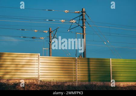 Linea ferroviaria elettrica polo di tensione con fili e pesi in calcestruzzo, messa a fuoco selettiva Foto Stock