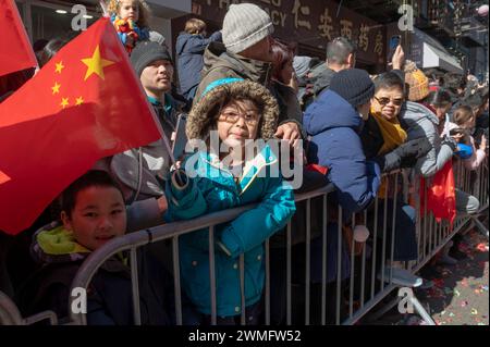 New York, Stati Uniti. 25 febbraio 2024. I bambini assistono alla parata annuale del Capodanno lunare a Chinatown il 25 febbraio 2024 a New York. Le persone si sono riunite per godersi e celebrare la 26a parata annuale del capodanno lunare, commemorando la fine dei 15 giorni che onorano la prima luna nuova del calendario lunare. Il 2024 è l'"anno del Drago". Credito: SOPA Images Limited/Alamy Live News Foto Stock