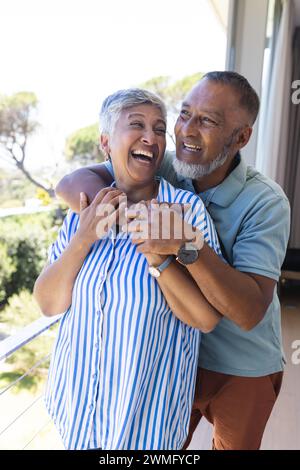 Una coppia birazziale senior condivide un momento di gioia all'aperto Foto Stock