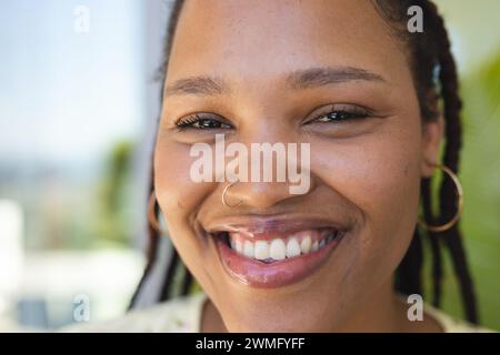 La giovane donna birazziale sorride brillantemente Foto Stock