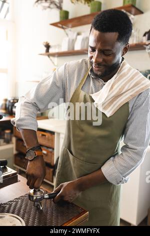 Il barista afroamericano maschile prepara il caffè in un bar Foto Stock