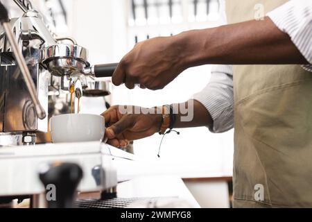 Il barista afroamericano prepara il caffè in un bar Foto Stock